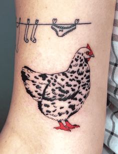 a chicken on the side of a woman's leg with clothes pins attached to it