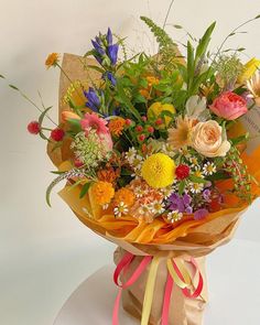 a bouquet of flowers is wrapped in brown paper