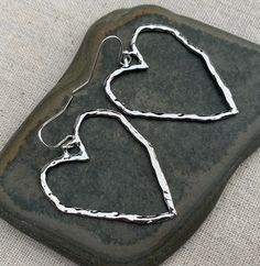 "Big, bold and chic! Open silver heart earrings are simple and stylish. These earrings make a statement about love, peace and happiness. They would make an awesome gift for a loved one too. The earrings measure 1 1/2\" long by 1 1/4\" wide. They hang from simple silver ear wire hooks. Overall drop length is 1 5/8\". Made from allergy free plated silver. I have a matching necklace in my shop if you would like the whole set. Here is a direct link https://etsy.me/3sYR0xv Thanks for stopping by! Ple Modern Heart-shaped Hoop Earrings For Gift, Modern Heart-shaped Hoop Earrings Gift, Modern Sterling Silver Heart Earrings For Gift, Nickel-free Heart Earrings For Everyday Wear, Modern Heart-shaped Earrings For Anniversary, Modern Heart Earrings For Valentine's Day Gift, Everyday Nickel-free Heart Earrings, Modern Heart Earrings With Heart Charm As A Gift, Modern Heart Charm Earrings As Gift