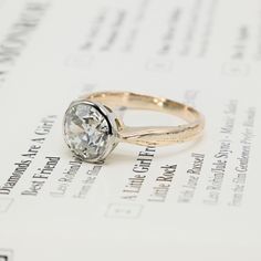 an engagement ring sitting on top of a piece of paper