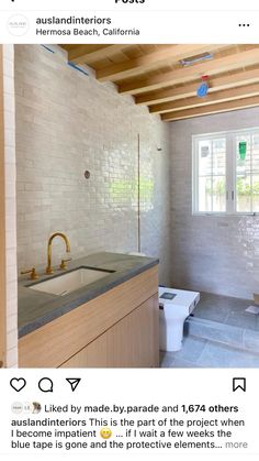 an instagramted photo of a bathroom with white brick walls and wood beams on the ceiling