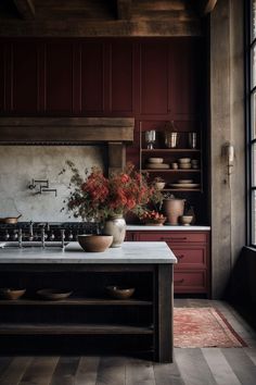 a kitchen with red cabinets and an island in front of the stove top is filled with flowers