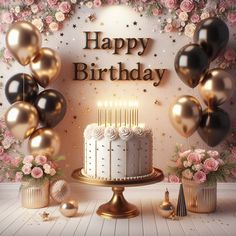 a birthday cake with candles surrounded by balloons and flowers on a wooden table in front of a backdrop that says happy birthday