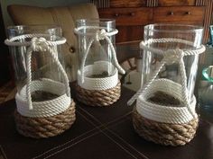 three glass vases with rope wrapped around them on top of a table next to a couch