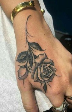 a woman's hand with a rose tattoo on it