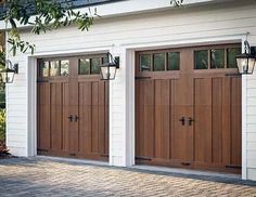 two brown garage doors in front of a white house