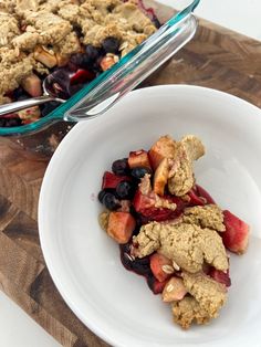 a white bowl filled with fruit next to a casserole dish