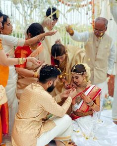 the bride and groom are getting ready to exchange rings on their guests'fingers as they sit in front of them