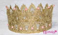 a gold tiara with pink beads on it's sides and a white background