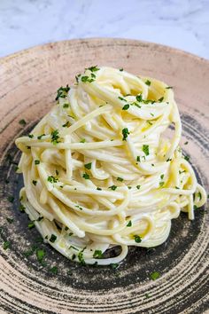 a close up of a plate of food with noodles and parsley on it,