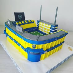 a cake made to look like an inflatable soccer stadium with yellow and blue accents