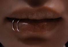 a woman's lips with two thin rings on her lip and one ring in the middle