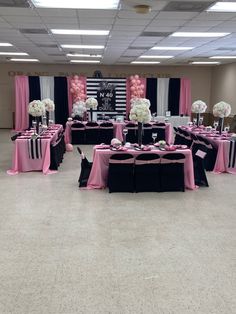 a banquet hall decorated with black and pink linens, white hydrangeas and centerpieces