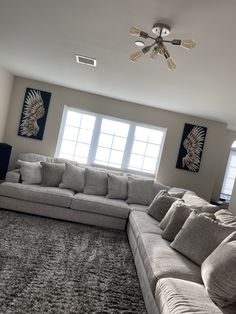 a living room filled with furniture next to two windows and a rug on the floor