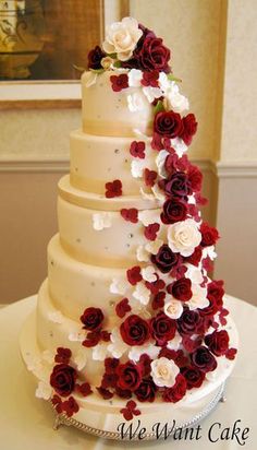 a wedding cake with red and white flowers on it