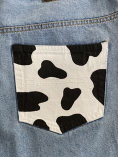 the back pocket of a pair of jeans with black and white cow print on it