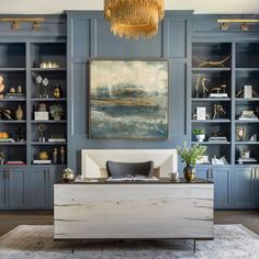 a living room with blue bookcases and a large painting on the wall above it