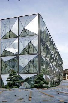 a glass building with trees in front of it