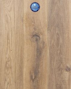 a wooden floor with a blue and white sticker on the wood grained surface