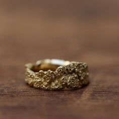 a close up of a gold ring on a wooden surface