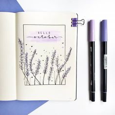 an open notebook with watercolor and ink on it next to a purple marker pen