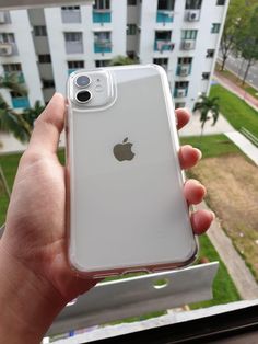 someone is holding up their iphone in front of an apartment building and looking out the window