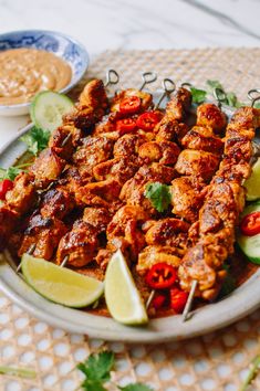 a plate full of chicken skewers and garnished with cilantro