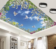 the ceiling is decorated with white flowers and birds flying in the blue sky above it