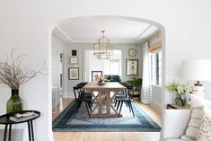 a dining room table with chairs and a rug on the floor in front of it