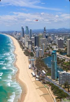 an aerial view of the gold coast with high rise buildings in the foreground and blue water