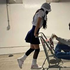 a woman pushing a shopping cart with a child in it