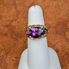 Estate/ vintage 14KT yellow gold checkerboard, oval, genuine, purple amethyst, gypsy-set multi gemstones, and diamond ring. Wide, cigar band style with vibrant colors. Size 6 Can be resized by us for a fee, or your local jeweler Ring weight: 4.90 DWT (4) Diamonds on prongs 13.8mm x 10mm center, oval, checkerboard faceted amethyst stone set in yellow gold. Gypsy-set, multi gemstones including citrine, tourmalines, etc. Stamped 14K and Hallmarked B & M Oval Amethyst Ring With Gemstone Accents, Oval Purple Amethyst Ring With Gemstone Accents, Collectible Oval Rings With Gemstone Accents, Luxury Oval Amethyst Collectible Ring, Oval Amethyst Gemstones With Gemstone Accents, Oval Amethyst Gemstones With Accents, Heirloom Oval Amethyst Ring With Accent Stones, Heirloom Purple Rings With Gemstone Accents, Purple Oval Cabochon Fine Jewelry