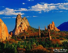 the mountains are surrounded by trees and rocks with blue sky in the backgroud