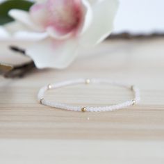 Start your stack with this dainty 2mm Rainbow Moonstone stretch bracelet.  The white/pinkish tint of the rainbow moonstone is accented with 14/20 14k gold-filled beads - resistant to tarnish.  This is one of many of our beautiful layering bracelets that is perfect for a delicate, understated look on its own as well as for parking with our gold filled or sterling silver bracelets in our Classico collection. This bracelet is hand-strung using high quality, Grade A semi-precious gemstones.  It is waterproof and meant to last! Delicate Stackable Beaded Bracelets As Gift, Dainty Faceted Beaded Bracelets For Everyday Wear, Delicate Stackable Beaded Bracelets With Round Beads, Dainty Beaded Bracelets With Faceted Beads, Adjustable Dainty Stretch Bracelet, Delicate Stackable Everyday Beaded Bracelets, Delicate Stackable Beaded Bracelets For Everyday, Dainty Stackable Stretch Bracelet As Gift, Dainty Stretch Bracelet With Faceted Beads For Gift