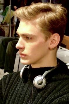 a young man with headphones on his ears is looking off to the side in a hair salon