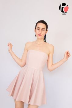 a woman in a short pink dress posing for the camera with her arms out and hands up