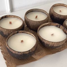 four coconut shell candles sitting on top of a table