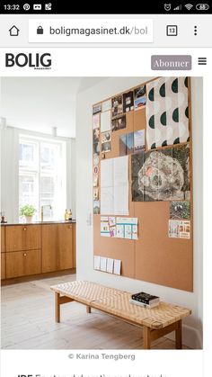 a wooden bench sitting in front of a bulletin board