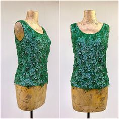 * Fancy sleeveless cocktail shell c 1960s * Lightweight green wool body is covered with iridescent green sequins, dangling strands of seed beads and faceted green plastic beads * Squared hem * Back opens completely with metal zipper * Fully lined in green rayon Label: Made in Hong Kong for Orbach's - 100% Wool - 36 Excellent condition Bust: 36 Waist: 34 Shoulder: 14 Length: 21 Garments are flat-measured. Please compare these measurements to another flat-measured garment that fits you correctly f Vintage Spring Tank Top For Party, Green Sleeveless Evening Tops, Green Sleeveless Sequin Top, Fitted Vintage Beaded Tops, 1960s Crop Top, Vintage Beaded Fitted Tops, Vintage Beaded Sleeveless Top, Beaded Shell, 1970 Dress