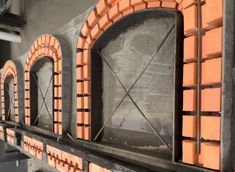 an old brick oven is being built into the side of a building with arched windows