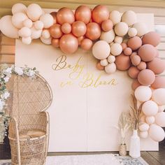 a baby is in bloom backdrop with balloons and wicker chairs on the front porch