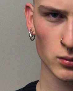 a young man with piercings on his nose and nose ring in front of him