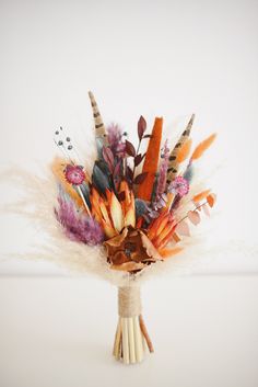 an arrangement of feathers and flowers in a vase