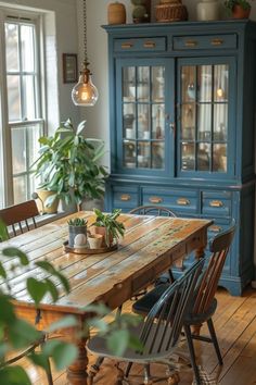 a dining room table with chairs and a potted plant in the middle of it