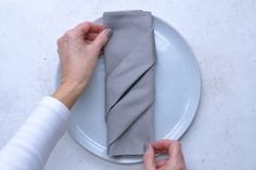 a person holding a napkin on top of a white plate