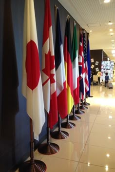 several flags are lined up in a row on the floor next to a blue wall