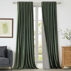 a living room with green curtains and a chair