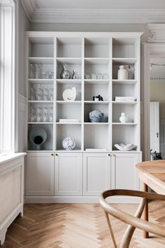 an empty room with white shelves filled with dishes