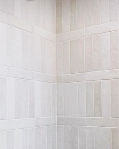 a white tiled shower stall with no curtain