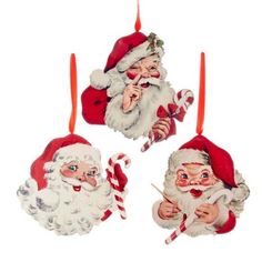 three santa claus ornaments hanging from strings